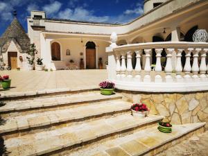 un edificio con scale e fiori in vasi di Trullo Suite a Cisternino
