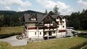 a large house with a black roof at OSRODEK WCZASOWY HANKA in Zawoja