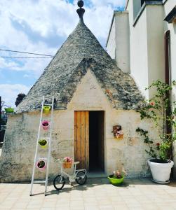 a building with a steep roof with a bicycle in front at Trullo Suite in Cisternino