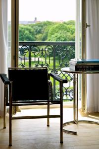 a chair and a table in front of a balcony at Leopold5 Luxe-Design Apartment in Ostend