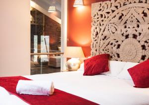 1 dormitorio con 1 cama blanca grande con almohadas rojas en Casa del Ocejón, en Majaelrayo