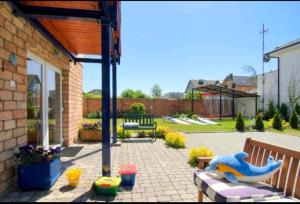 a backyard with a patio with a bench and a patio at Villa Baltic -Apartament nr 9 in Chałupy