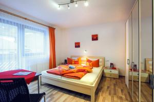a bedroom with a bed with orange pillows on it at Appartement Gisela in Sölden