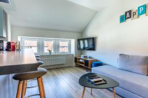 uma sala de estar com um sofá e uma mesa em Le 201-GregIMMO-Appart'Hôtel em Audincourt