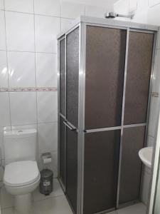 a bathroom with a shower with a toilet and a sink at Hotel Athenas e Convenções in Araçatuba