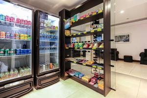 a store aisle with two refrigerators and food at Sandri City Hotel in Balneário Camboriú +100 photos