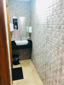 a bathroom with a sink and a mirror at Hotel Barão in São Paulo