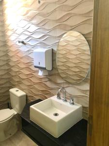 a bathroom with a sink and a mirror and a toilet at Hotel Barão in Sao Paulo