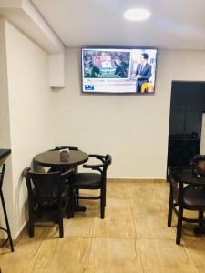Hotel Barão في ساو باولو: غرفة مع طاولة وكراسي وتلفزيون على الحائط