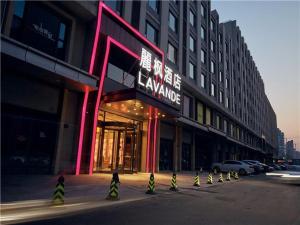un edificio con insegne al neon sul lato di una strada di Lavande Hotel Jinan High-Tech Wanda Exhibition Center a Jinan