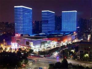 Lavande Hotel Jinan High-Tech Wanda Exhibition Center في جينان: مدينة مضاءة ليلا مع مباني طويلة