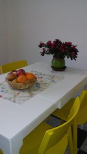 a table with a bowl of fruit and a vase with flowers at Rezi in Slap ob Idrijci