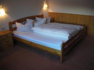 sypialnia z dużym łóżkiem z białą pościelą i poduszkami w obiekcie Appartement Susanne w Neustift im Stubaital