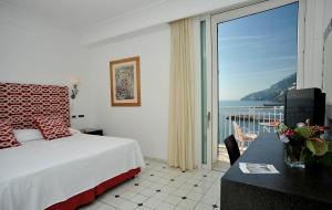 a hotel room with a bed and a view of the ocean at Hotel Marina Riviera in Amalfi