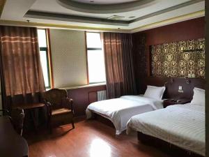 a hotel room with two beds and a chair at 7days Inn·Zibo Zhoucun Taoyuan Ginza Branch in Zibo