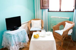 een kamer met een tafel en twee stoelen en een televisie bij Hotel Rural La Llosa de Fombona in Luanco