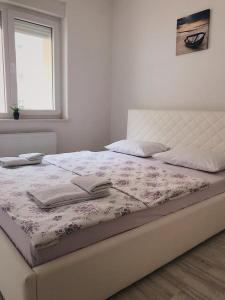uma cama com duas toalhas num quarto em Blini Complex em Pristina
