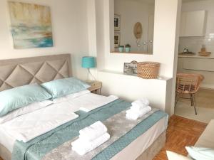 a bedroom with a bed with towels on it at Sunshine Residence in Stara Baška