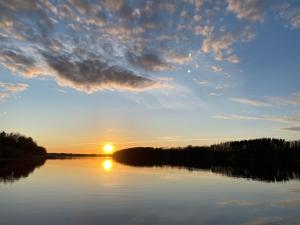 a sunset on a lake with the sun setting at Piešupīte in Staburags