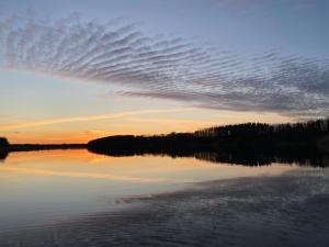 una formación lenticular de nubes sobre un lago al atardecer en Piešupīte en Staburags