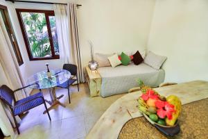 a living room with a couch and a table with a bowl of fruit at Recanto da Mata Pipa in Pipa