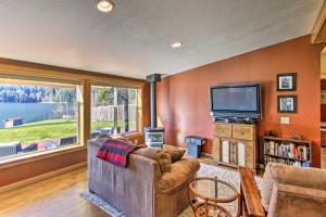 a living room with a couch and a tv at Lakefront Eatonville Cabin w/ Dock & Mtn Views! in Mineral