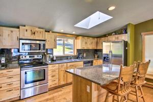 a kitchen with wooden cabinets and stainless steel appliances at Lakefront Eatonville Cabin w/ Dock & Mtn Views! in Mineral