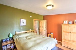 Mineral的住宿－Lakefront Cabin with Stunning Mountain Views and Dock!，卧室拥有绿色和橙色的墙壁,配有一张床