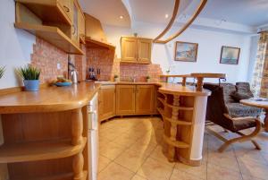 a kitchen with wooden cabinets and a counter top at Apartamenty w Helu in Hel