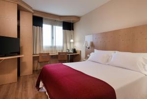 Habitación de hotel con cama grande y escritorio. en Hotel Logroño Parque, en Logroño