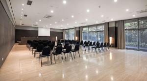 バリャドリッドにあるHotel Ciudad de Valladolidの椅子とプロジェクションスクリーン付きの広い客室です。