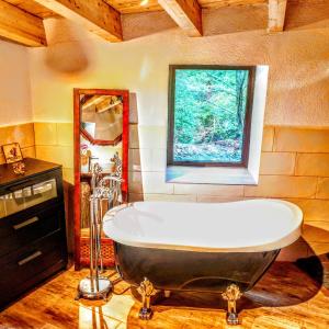 eine große Badewanne im Bad mit Fenster in der Unterkunft El moli del montseny in Fogás de Monclús