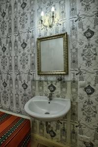 baño con lavabo y espejo en la pared en Pension Friedrich-Wilhelm en Berlín