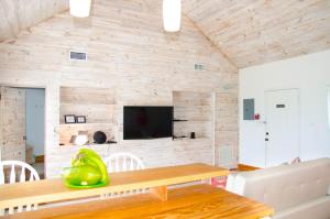 een kamer met een houten muur met een tafel en een televisie bij Ocean View Cottage - At Orange Hill in Nassau