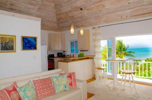 a living room with a couch and a kitchen at Ocean View Cottage - At Orange Hill in Nassau