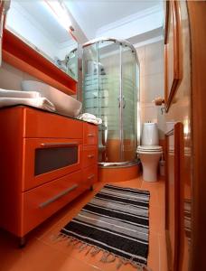 a bathroom with a sink and a shower and a toilet at NEFELI apartments in Poros
