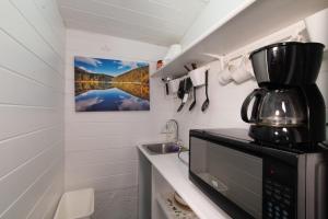 eine kleine Küche mit Mikrowelle und Spüle in der Unterkunft Garden Cottage - At Orange Hill in Nassau