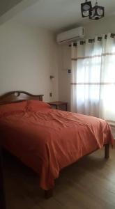 a bedroom with a red bed and a window at Hotel el super 8 in Santa Cruz de la Sierra