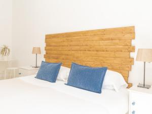a bedroom with a white bed with blue pillows at Dulces Dreams Boutique Hotel in Málaga