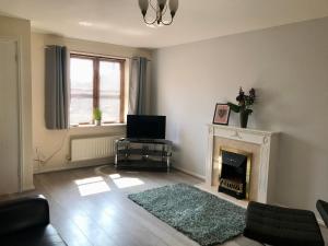 a living room with a fireplace and a television at Kettering Leisure Holiday Home in Kettering