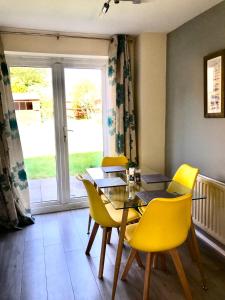 una sala da pranzo con tavolo e sedie gialle di Kettering Leisure Holiday Home a Kettering