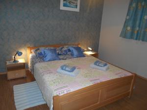 1 dormitorio con 1 cama con 2 almohadas azules en Apartments Jerkin, en Tribunj