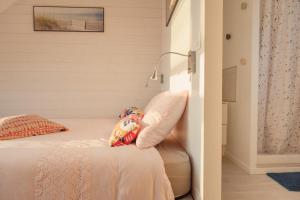 Dormitorio con cama con almohada y lámpara en Les Chambres d'Hôtes de la Mer, en Merlimont-Plage