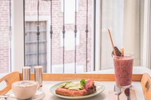 una mesa con un plato de comida y una bebida en Dulces Dreams Boutique Hotel, en Málaga