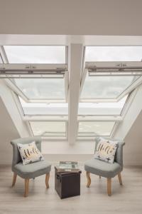 梅利蒙海灘的住宿－Les Chambres d'Hôtes de la Mer，客房设有两把椅子和天窗天花板。
