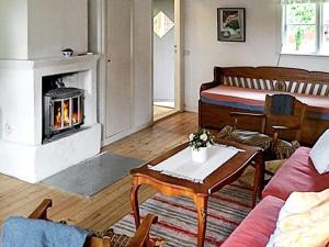 uma sala de estar com lareira e uma cama em 6 person holiday home in LOFTAHAMMAR em Loftahammar
