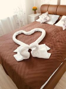 een bed met twee handdoeken in de vorm van een hart bij Apartament Manu in Mamaia Nord – Năvodari