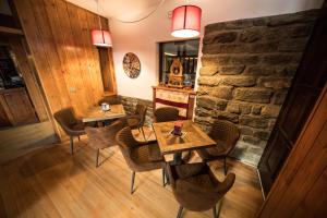 a restaurant with tables and chairs and a stone wall at Chalet Saint-Barthélemy Hotel in Nus