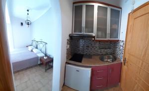 a kitchen with a sink and a bed in a room at NEFELI apartments in Poros
