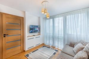 a living room with a couch and a sliding door at Apartment Strict Warsaw Center - Metro, Free Parking in Warsaw